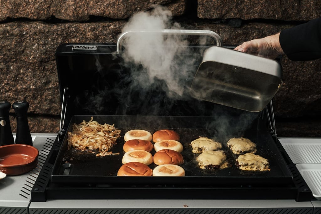 Weber Slate 71cm GPD med cheeseburgere, burgerbrød og løk.