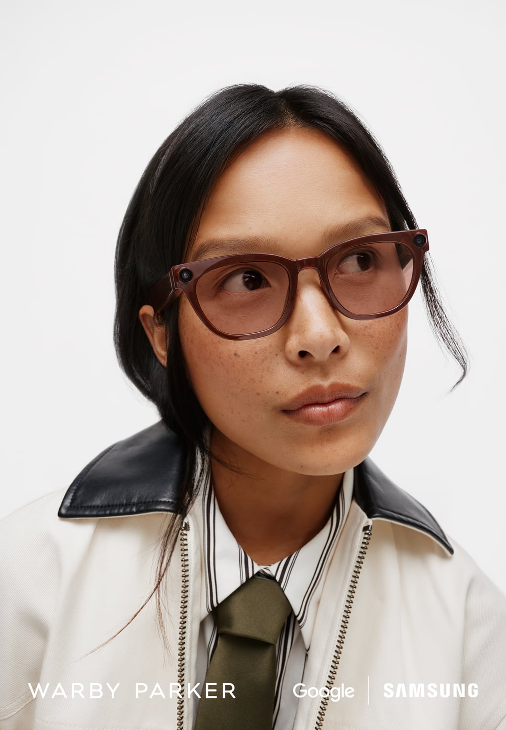 Kvinne med Warby Parker-utgaven av Samsungs smarte briller i brun innfatning med innebygd kamera