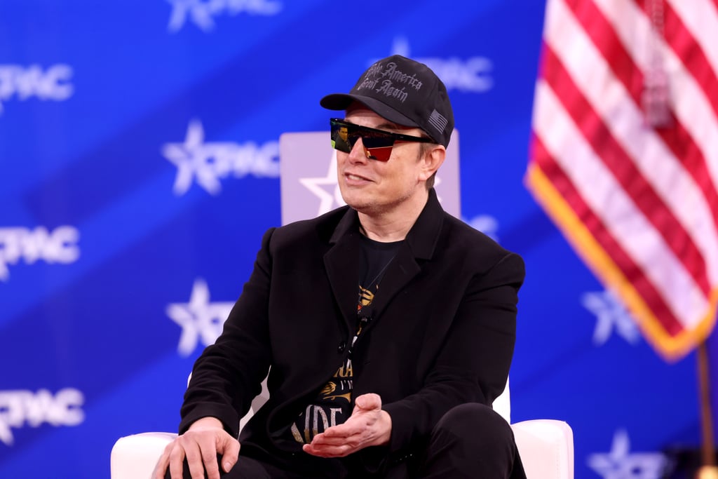 Elon Musk i svart caps og solbriller på scenen under CPAC i 2025