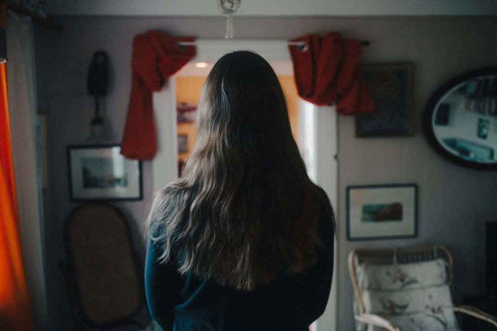 Testeren sett bakfra med langt, bølget hår før styling, i en stue med bilder på veggen