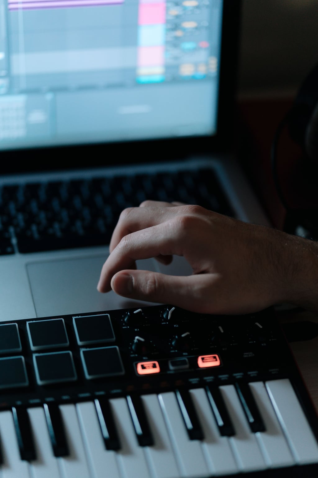 Nærbilde av en synthesizer koblet til en bærbar PC med lydproduksjonsprogramvare