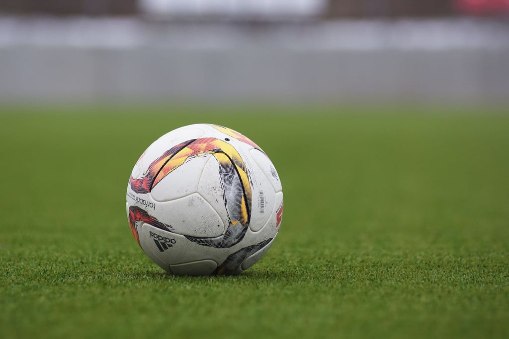 En Adidas-fotball på en gressbane