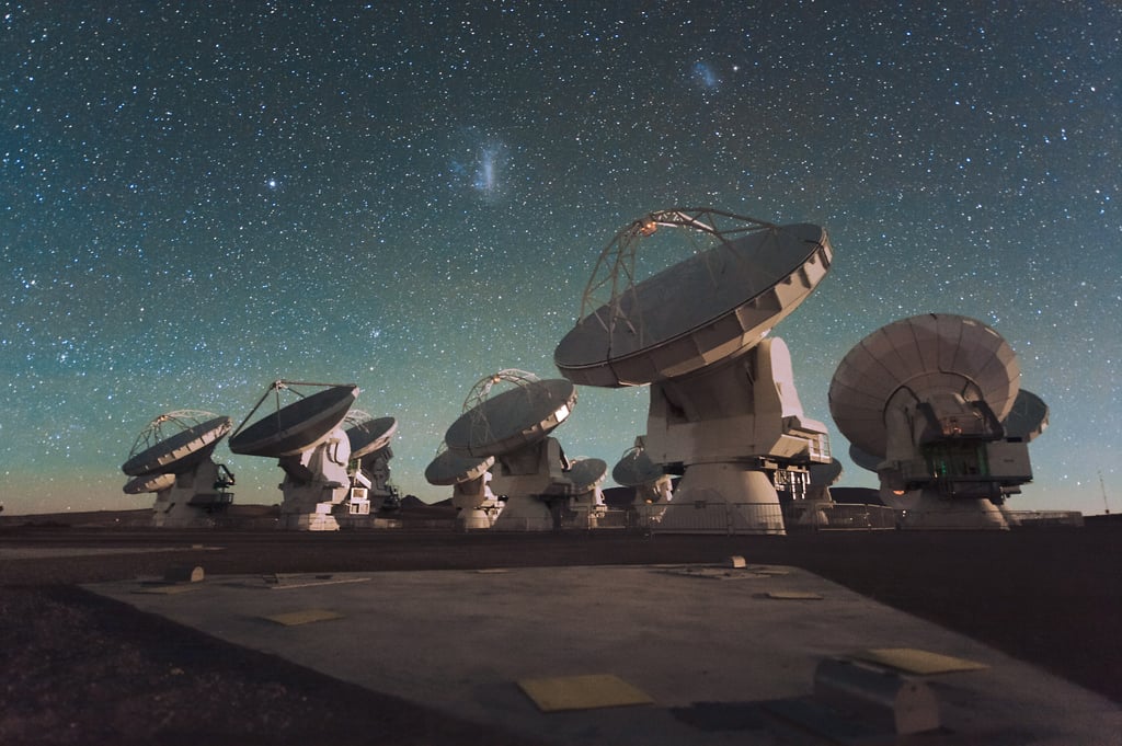 ALMA-antennene i Atacama-ørkenen under stjernehimmelen med de magellanske skyer