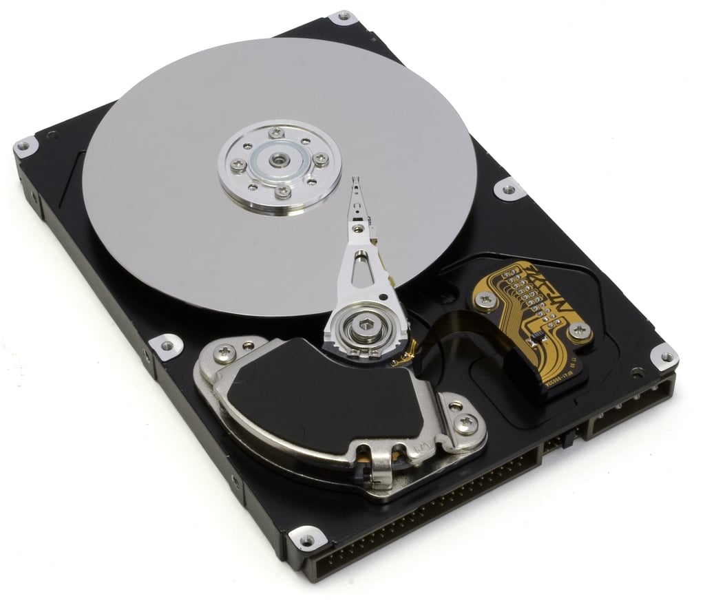 Åpen harddisk med lesehodet synlig over den blanke platen
