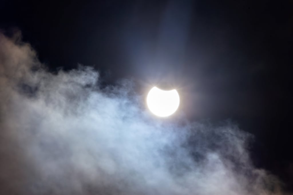 Delvis formørket sol bak et tynt skydekke, fotografert i Sverige i mars 2025