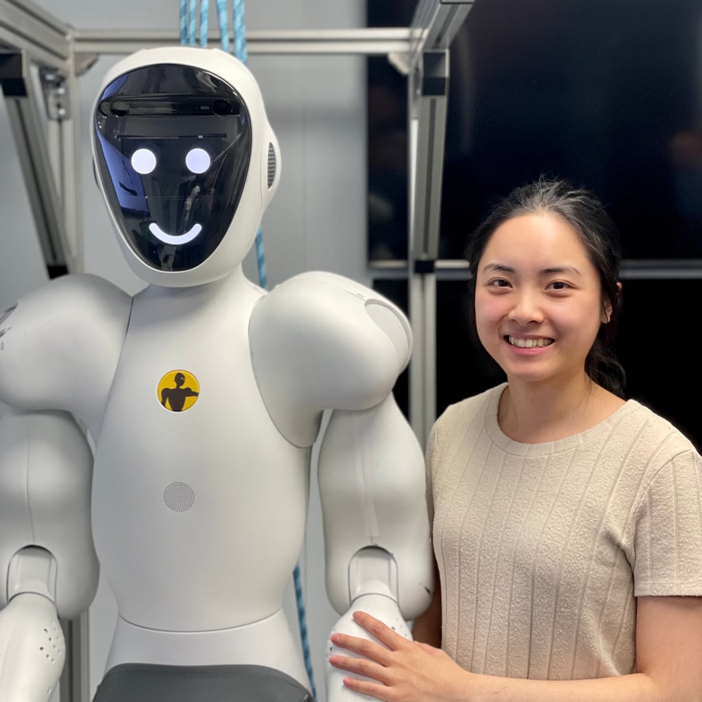 En ingeniør ved siden av en humanoid robot