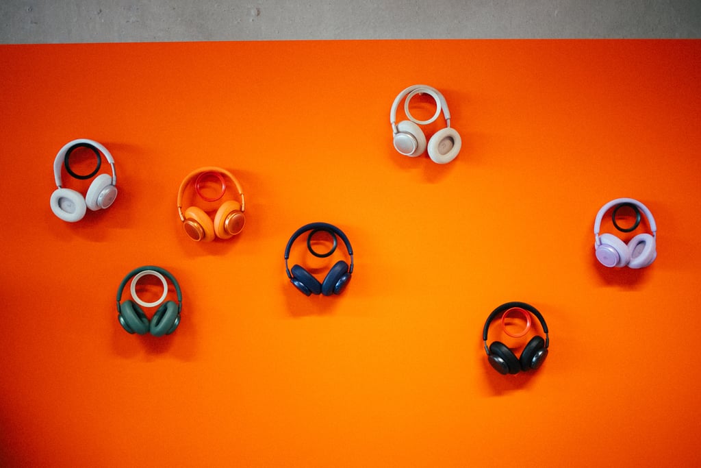 JBL Live 780NC hengende i seks farger på en oransje vegg under lanseringen i Amsterdam