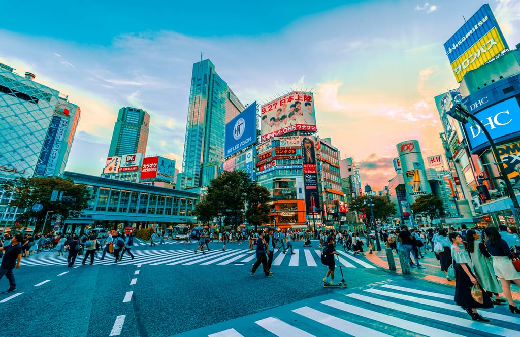 Fotgjengere krysser Shibuya-krysset i Tokyo en sommerdag