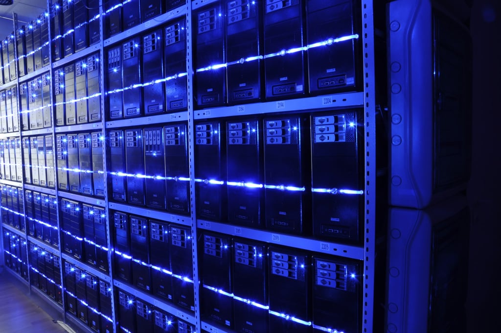 Rader med servere i et opplyst serverrom sett nedover midtgangen
