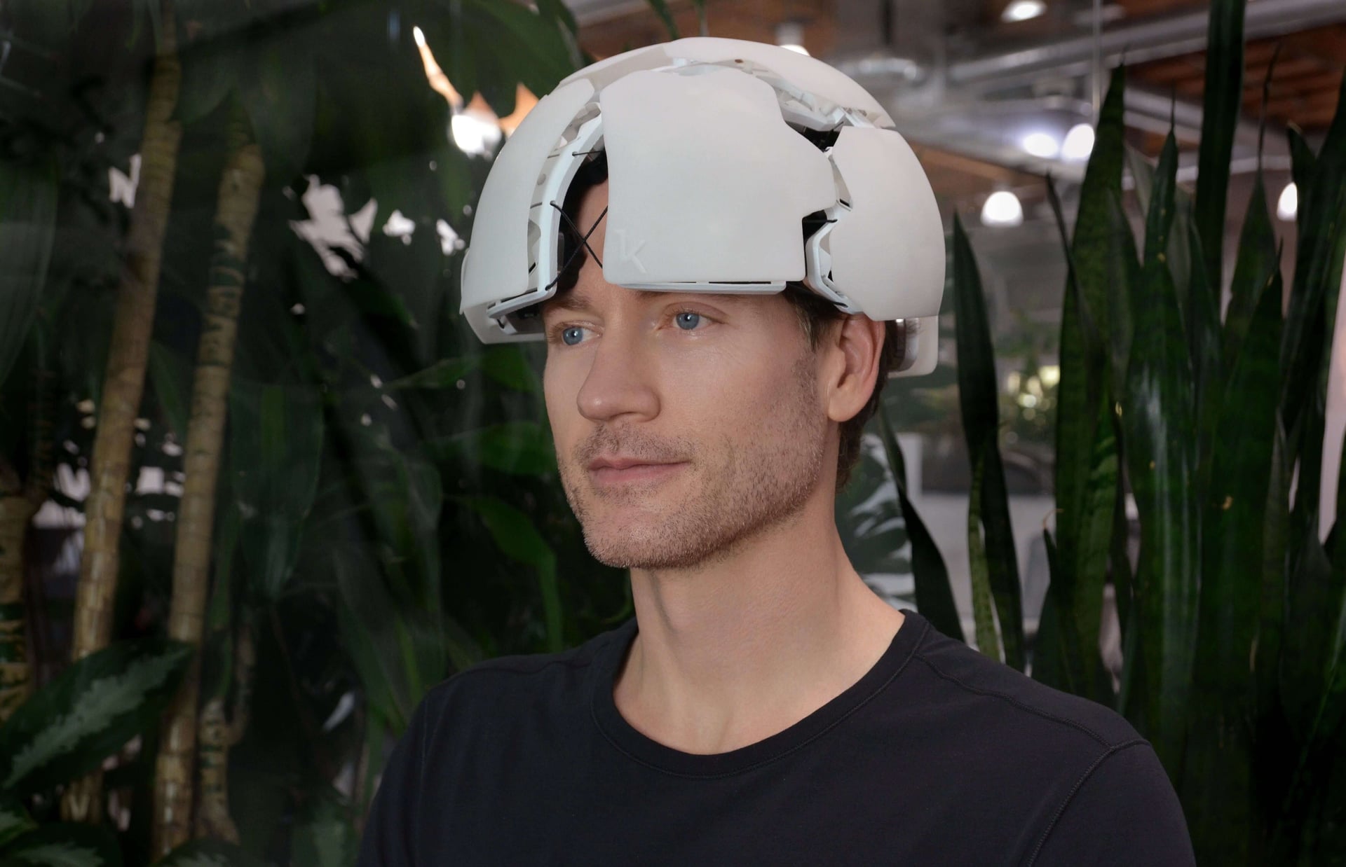 Bryan Johnson med en hvit hjerneskanner på hodet