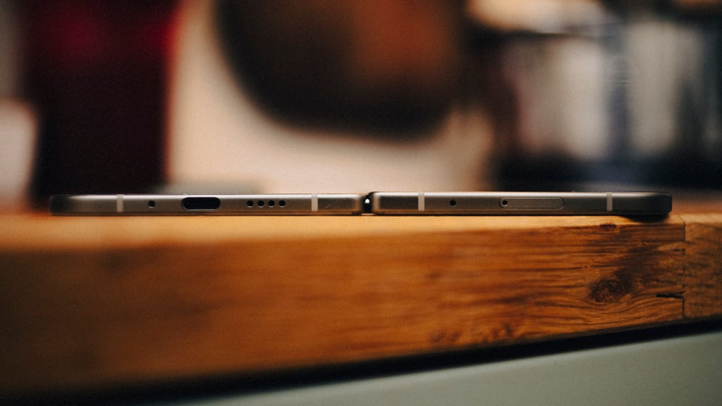 Google Pixel 11 Pro Fold utbrettet på en trebenk, sett fra siden langs undersiden