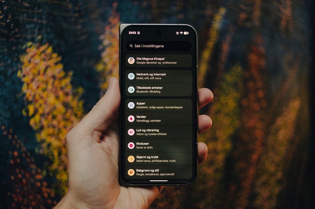 Hånd som holder Google Pixel 11 Pro Fold med Android-innstillinger på skjermen