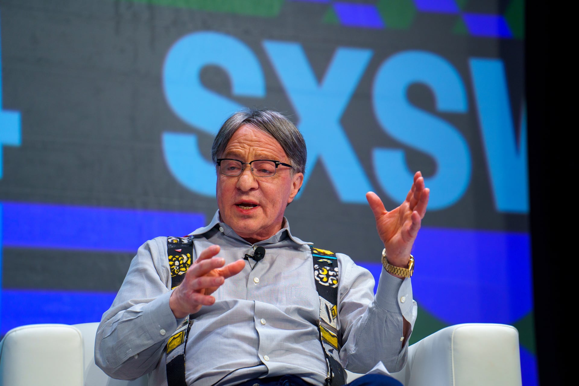 Ray Kurzweil gestikulerer i en hvit lenestol på scenen under SXSW 2024