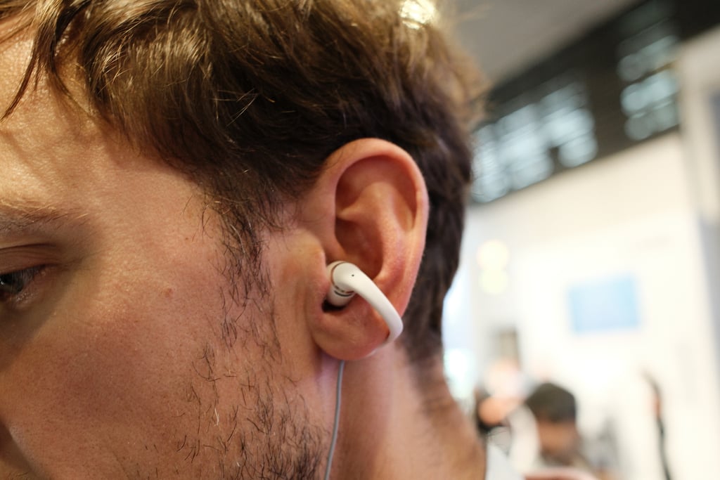 Hvit OpenDots-ørepropp som klemmer seg fast på ørekanten til en mann