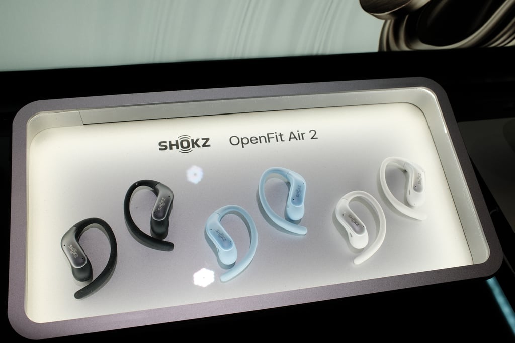 OpenFit Air 2 i sort, isblått og hvitt utstilt i en opplyst monter