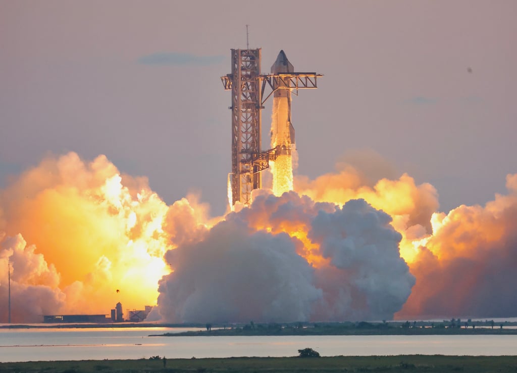Starship og Super Heavy letter fra oppskytningstårnet på Starbase i Texas i en sky av røyk