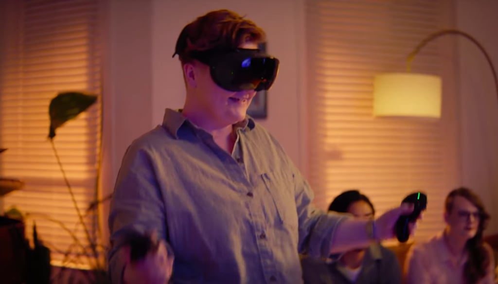 Mann med Steam Frame spiller med en kontroller i hver hånd i en stue