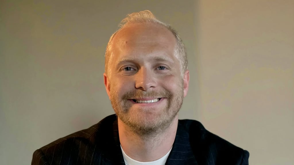 Stian Wensås i Samsung Norge, smilende i mørk stripete blazer og hvit t-skjorte