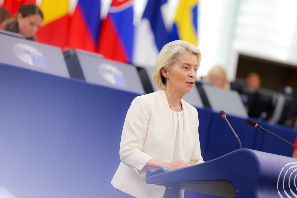 Ursula von der Leyen taler bak talerstolen i Europaparlamentet med EU-lands flagg bak seg