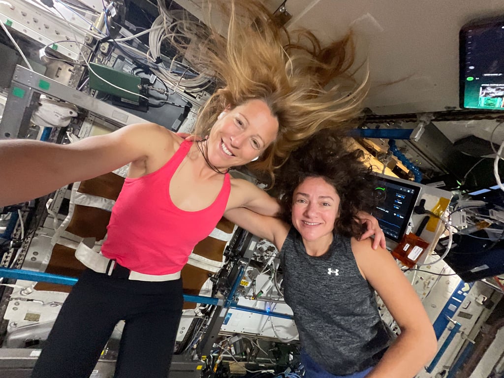 Astronautene Sophie Adenot og Jessica Meir svever i treningstøy på romstasjonen
