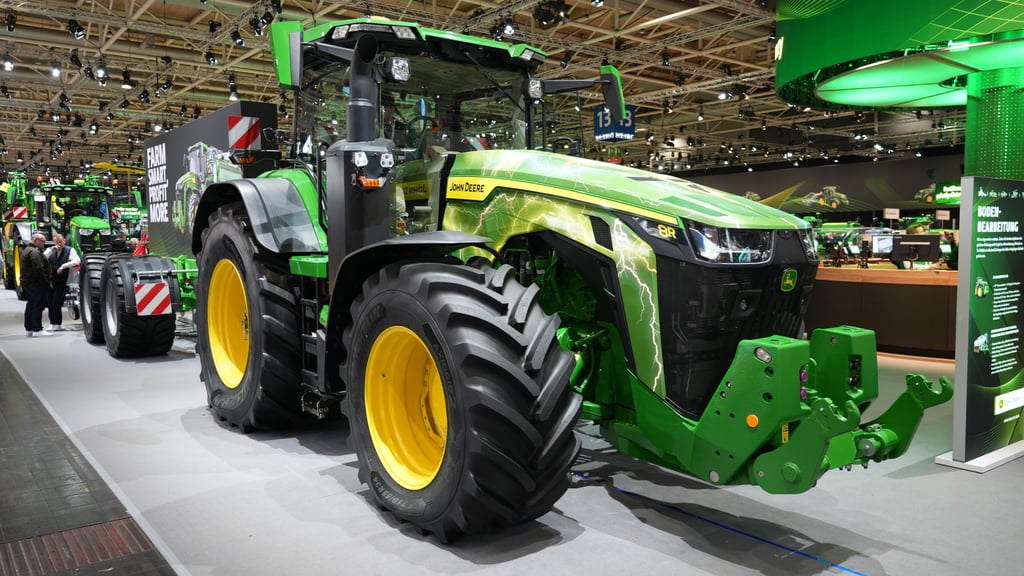 Grønn John Deere-traktor med gule felger på en landbruksmesse