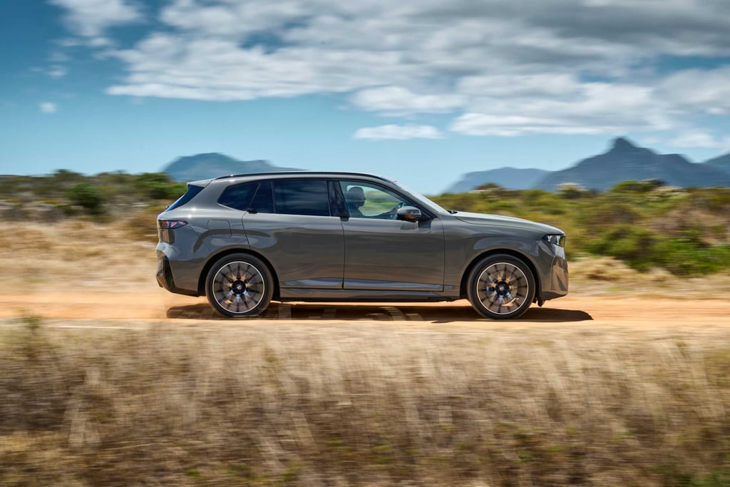 BMW iX5 60 xDrive fotografert fra siden på en grusvei