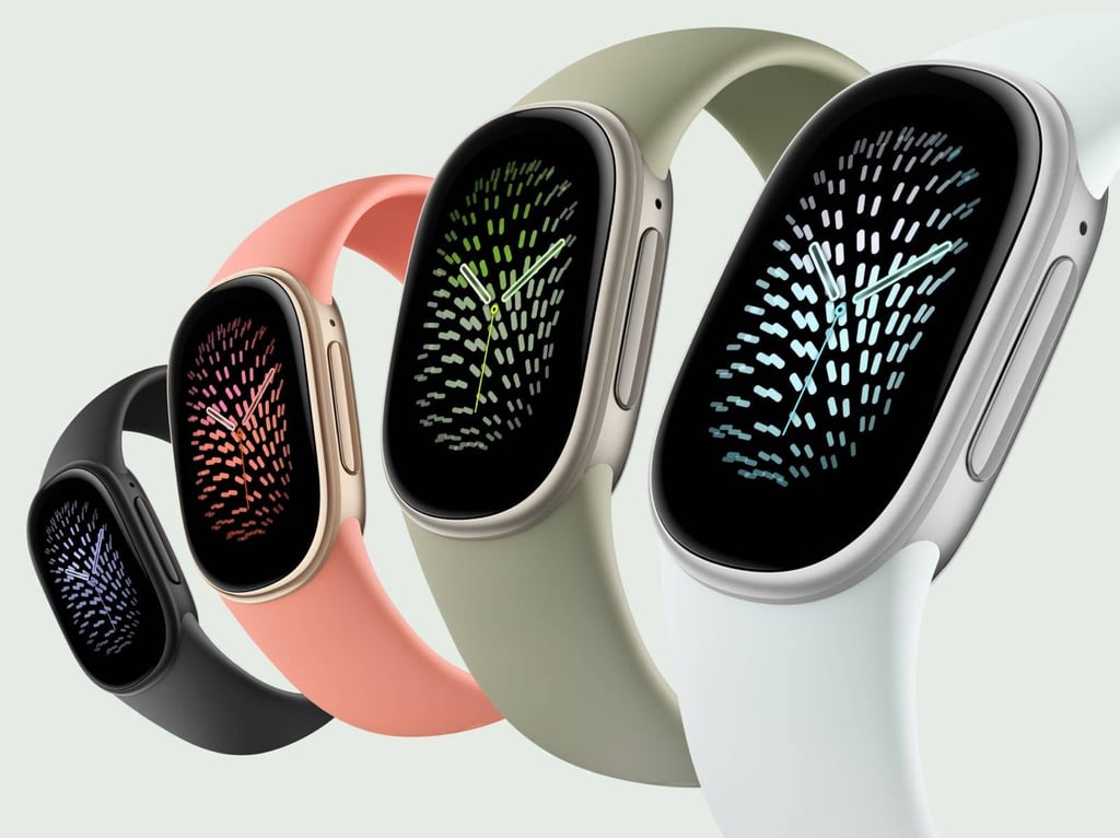 Fire Fitbit Edge-armbånd i sort, rosa, grønt og hvitt står på rekke mot lys bakgrunn