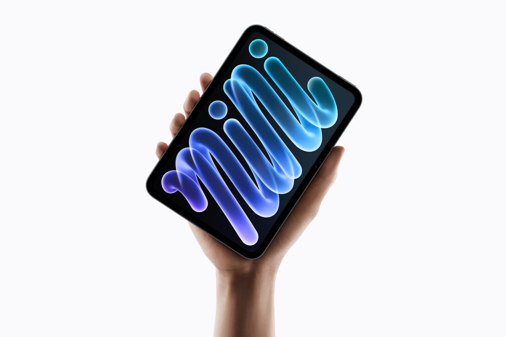 Nye iPad mini holdt i én hånd med skjermen påslått