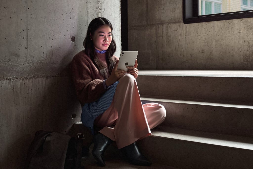 En person sitter i en trapp og leser på iPad mini