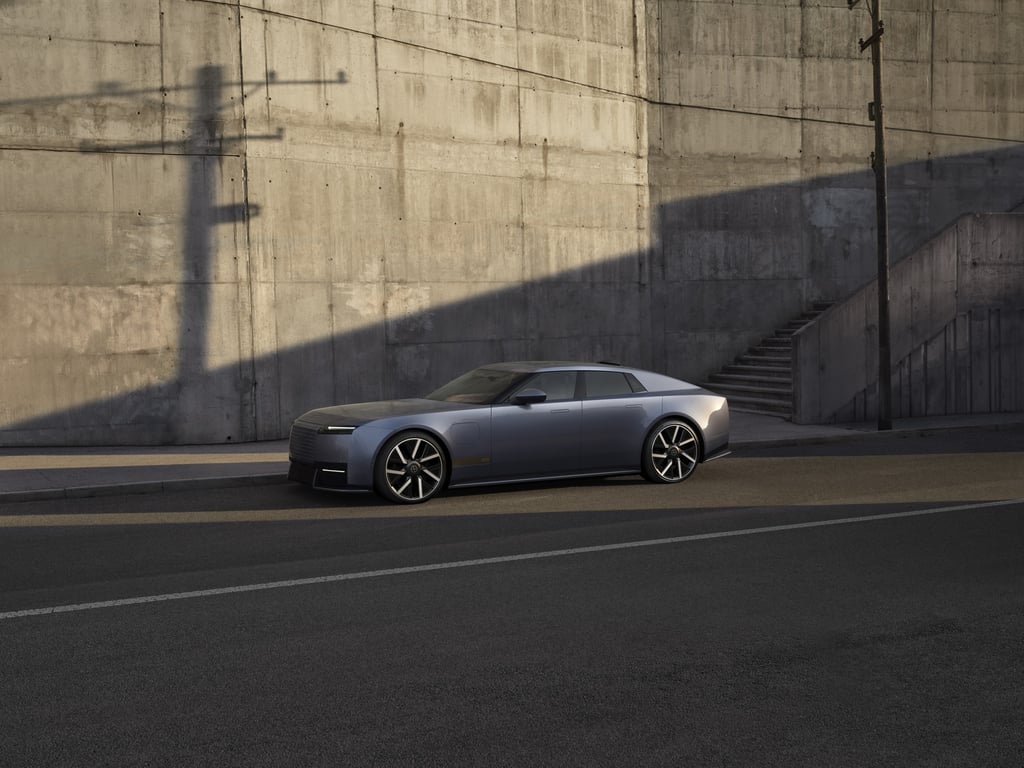 Blå Jaguar Type 01 sett skrått forfra ved en betongvegg
