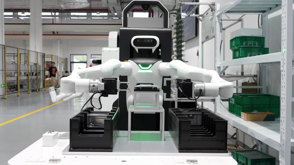 Hvit robot med overkropp og to armer løfter en kasse mellom to stativer i en fabrikkhall