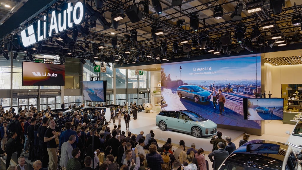Publikum og pressefolk samlet rundt en turkis Li 6 på Li Autos stand i Paris