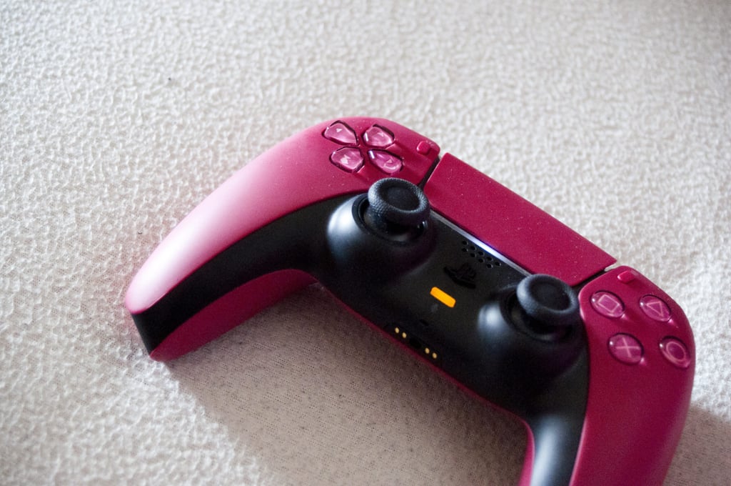Rød DualSense-kontroller til PlayStation 5 på et lyst teppe