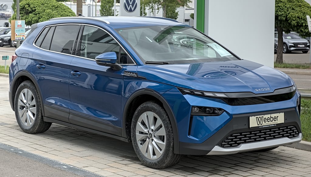 Blå Škoda Elroq parkert foran en bilforhandler