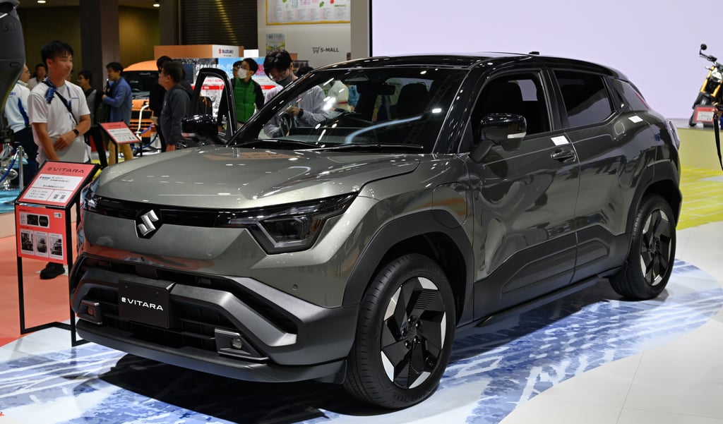 Hvit Suzuki e Vitara elbil parkert utendørs, sett skrått forfra fra venstre side