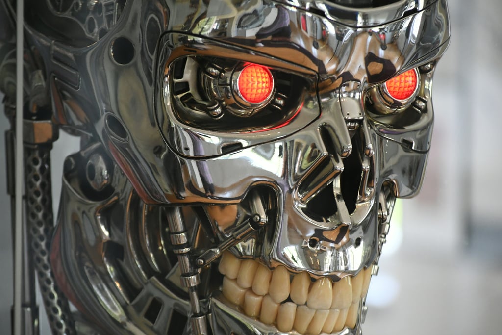 Forkrommet robothodeskalle med glødende røde øyne og blottede tenner, i Terminator-stil