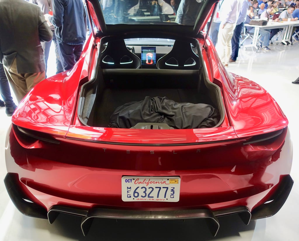 Rød Tesla Roadster-prototype sett bakfra med åpen bakluke og amerikansk nummerskilt