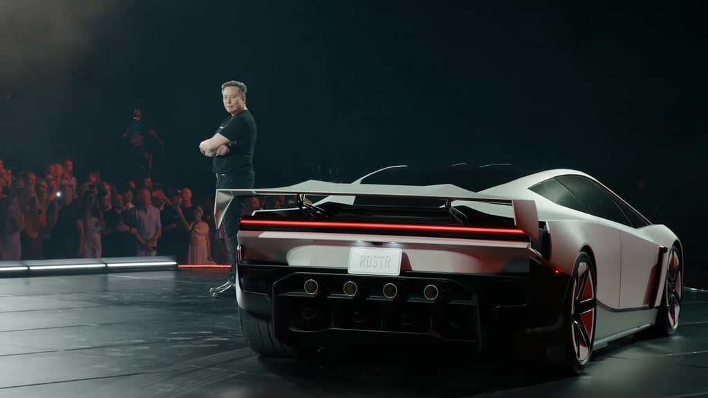 Elon Musk står med armene i kors bak nye Tesla Roadster foran publikum under avdukingen