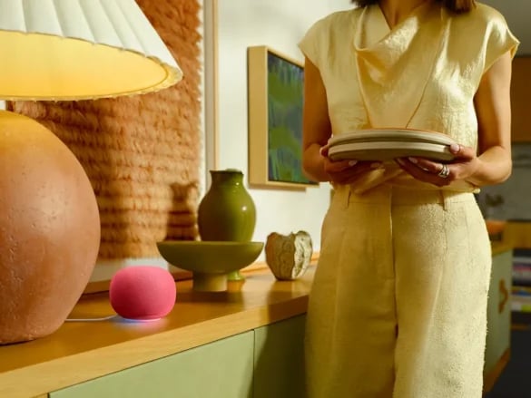 Familie i stue med Google Home-høyttaler i forgrunnen
