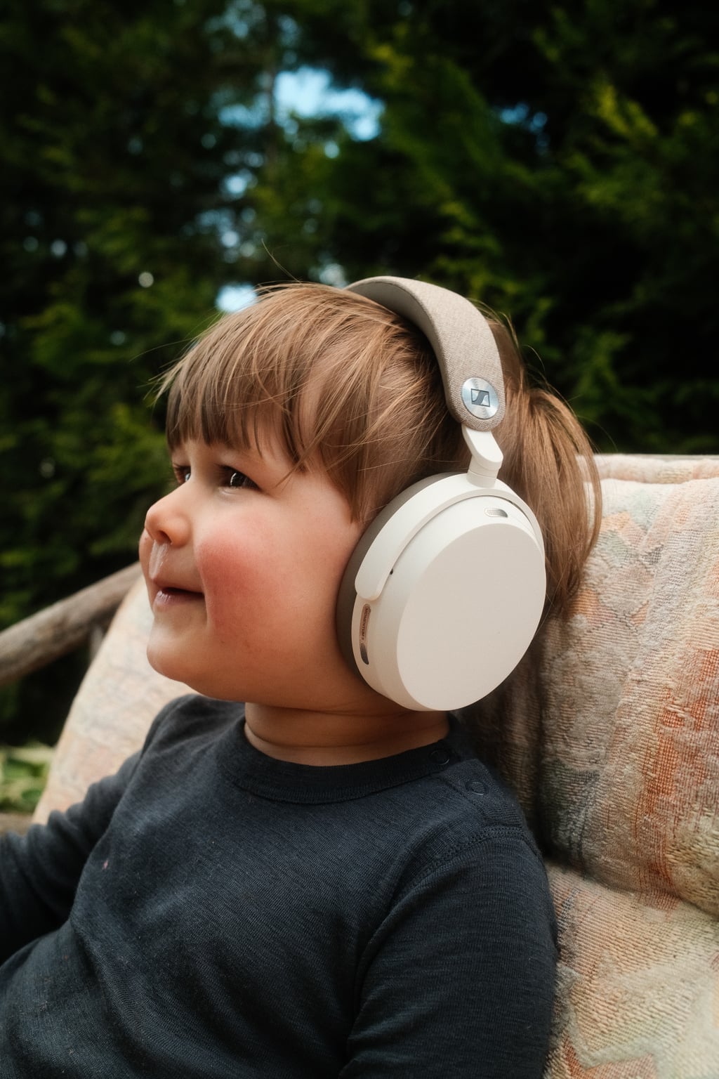 Toåring med Sennheiser Momentum 5 på hodet, ute i hagen