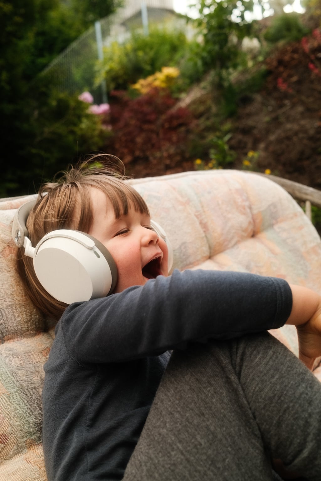 Toåring med Sennheiser Momentum 5 over ørene, ler med åpen munn