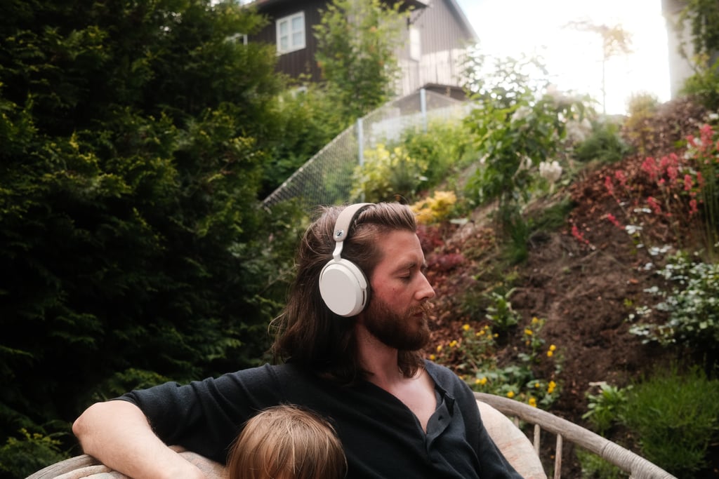 Julian i hagestol med Sennheiser Momentum 5 på hodet, toåringen på fanget
