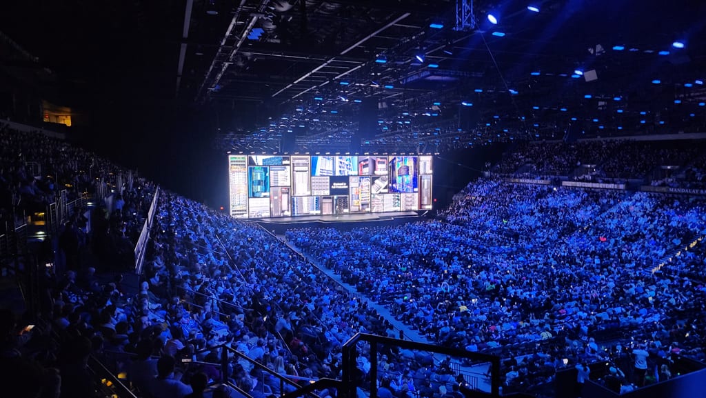 Jensen Huang på scenen i en fullsatt, blålyst arena under CES 2025