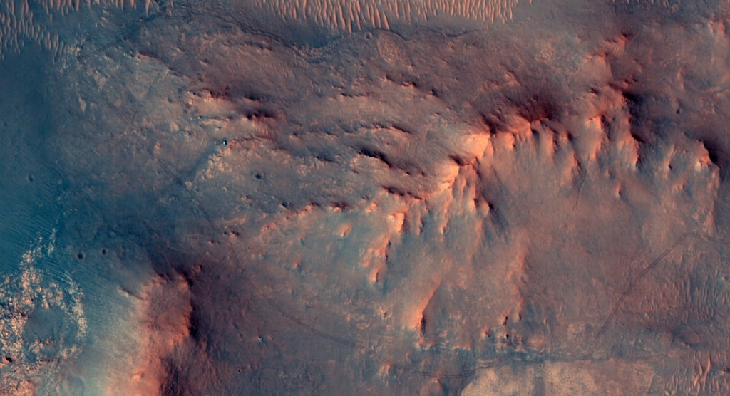 Perseverance-roveren sett ovenfra av HiRISE-kameraet på Mars Reconnaissance Orbiter, med hjulspor i sanden bak seg