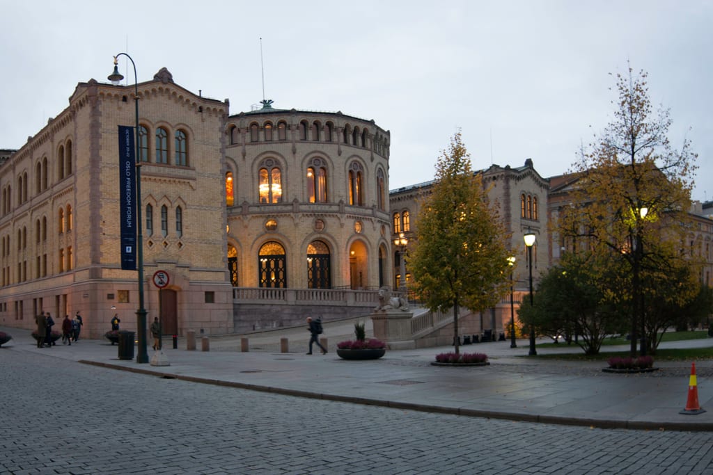 Stortingsbygningen i Oslo i skumringen, med Karl Johans gate til venstre.