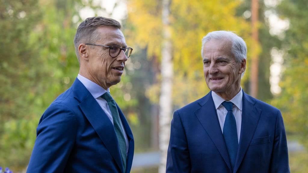 Alexander Stubb og Jonas Gahr Støre står ute i mørk dress foran høstgule bjørketrær.