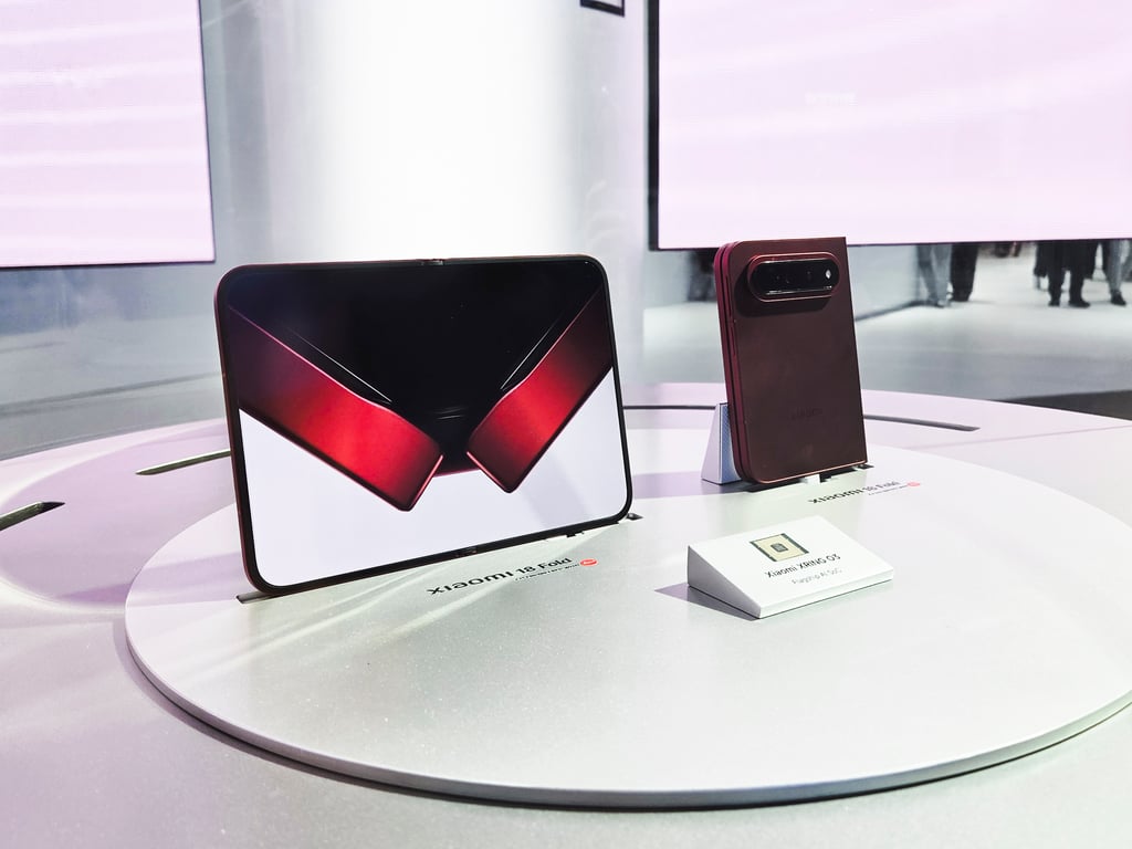 To Xiaomi 18 Fold på utstillingsbordet, én oppbrettet og én sammenbrettet, ved siden av Xring O3-brikken