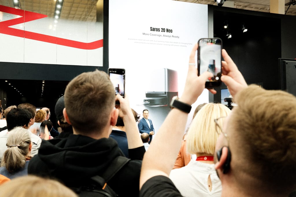 Publikum løfter mobiltelefoner mot scenen mens Roborock lanserer robotstøvsugeren Saros 20 Neo på IFA 2026