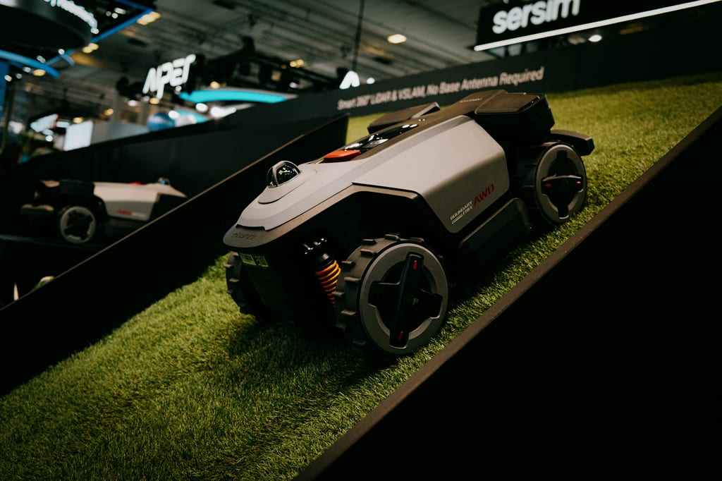 Robotgressklipperen RockMow Z1 LiDAR klatrer opp et bratt kunstgress-skråplan på Roborocks stand på IFA
