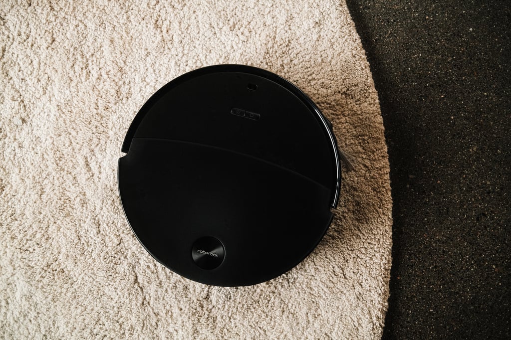 Roborock Saros 20 Neo sett rett ovenfra på et lyst, rundt teppe, med gulvet synlig til høyre